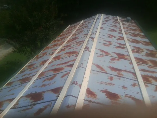 Rusted metal roof panels with new wood purlins before replacement — Storm Damage Roof Repair in Horse Branch by Roofing Brothers